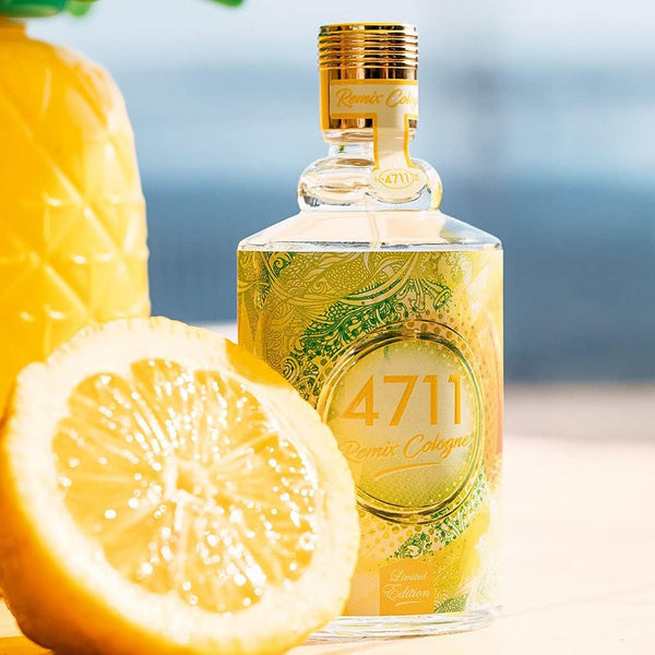 Bottle of 4711 cologne with a lemon and pineapple on a blurred beach background